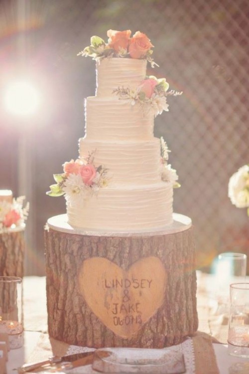 a white textural buttercream wedding cake decorated with white and pink blooms and greenery is a stylish rustic idea