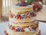 a naked wedding cake with fresh berries and sugar powder is a gorgeous and delicious rustic wedding dessert