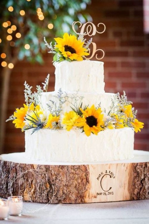 a white textural wedding cake with sunflowers, wildflowers and a monogram topper is a great thing for a rustic wedding
