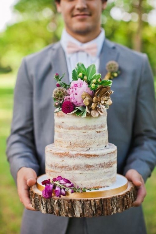 a naked wedding cake with bright blooms and greenery is a nice dessert for a rustic wedding