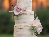 a naked wedding cake with gold leaf and pink blooms and greenery is a lovely idea for any rustic wedding