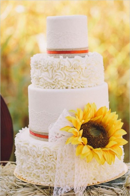 a white lace and patterned wedding cake with burlap, sunflowers and lace for a rustic chic wedding