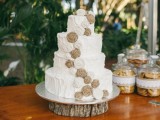 a white textural buttercream wedding cake decorated with white fabric and burlap blooms is a cool rustic idea