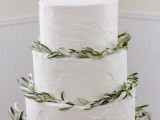 a lovely and chic white textural buttercream wedding cake decorated with fresh greenery is elegant and timeless