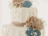 a white textural buttercream wedding cake with fabric blooms and baby’s breath is a lovely rustic wedding idea