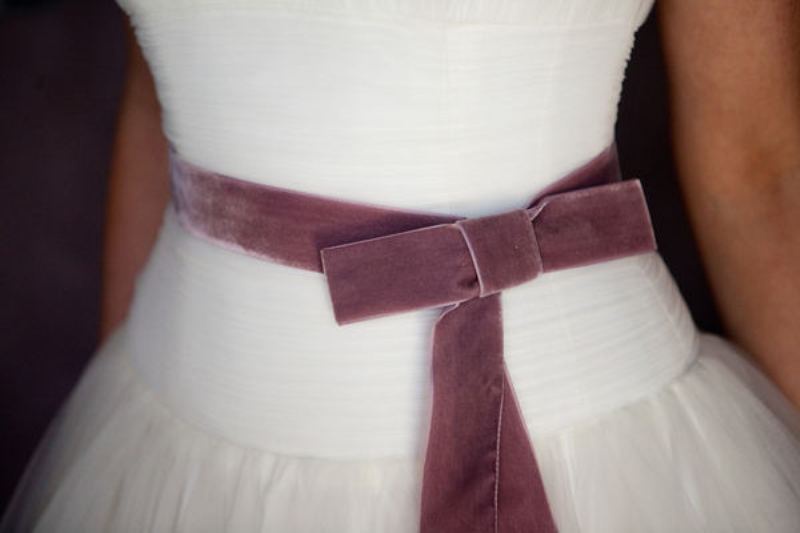 A delicate mauve velvet sash with a bow is a lovely solution for a wedding, it will add a slight touch of color to your look