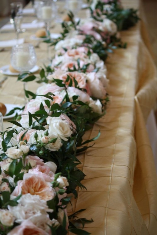 a lush greenery and pastel flower garland looks very tender and very romantic