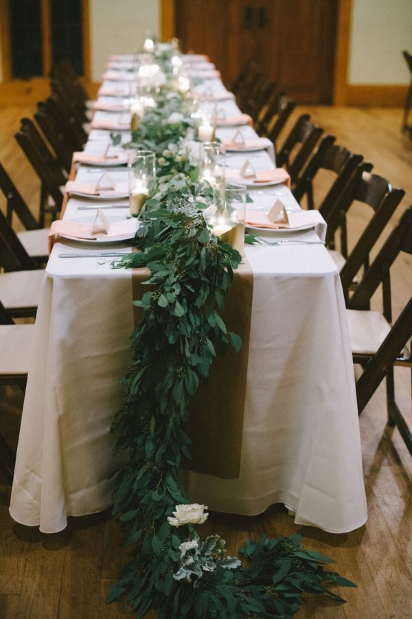 A lush greenery table dotted with some white blooms here and there for a more elegant and chic look