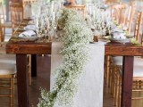 a lush baby’s breath table garland paired with a fabric table runner is classics that always works