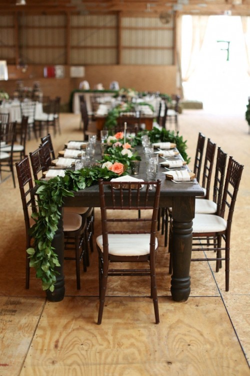 a greenery garland with white and peachy blooms is a pretty rustic idea to decorate the table