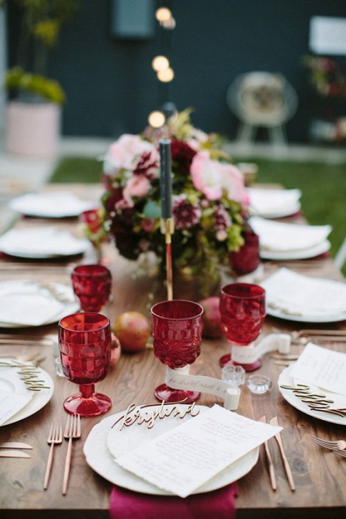 spruce up your wedding tablescape with marsala glasses, blooms and napkins to make it feel like fall and stand out with a colorful statement