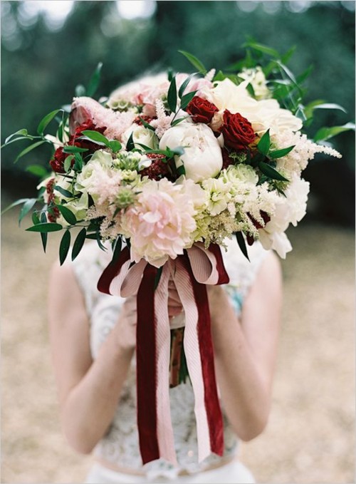 a beautiful wedding bouquet of white, blush and marsala blooms and some greenery plus marsala and blush ribbons, a lovely idea for the fall