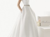a plain minimalist strapless wedding ballgown with an embellished sash and pockets for a wow look