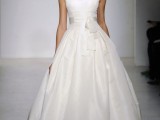 a minimalist wedding ballgown with no sleeves, a scoop neckline and a draped full skirt plus a sash