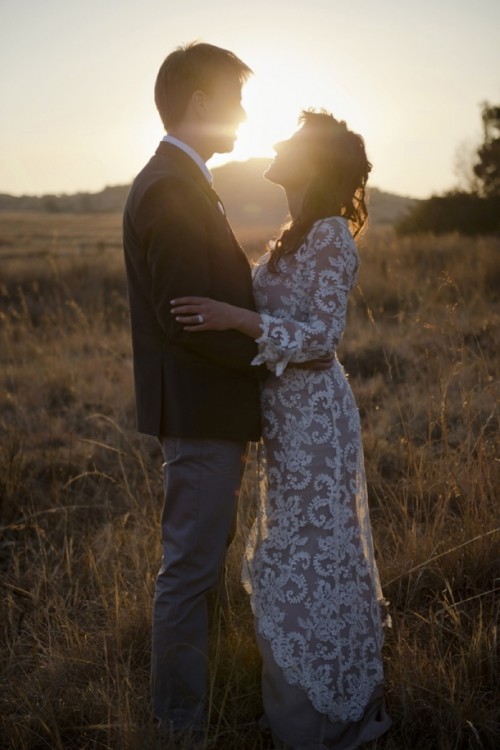 a fitting nude lace wedding dress with short sleeves and a high neckline for a casual sunset wedding ceremony