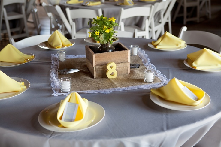 A box with greenery and yellow blooms is a nice and cute barn wedding centerpiece