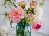 a blue jar with pink and neutral blooms plus greenery will be nice for a rustic or barn wedding