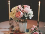 an elegant wedding centerpiece of a vintage vase with copper and white and pink blooms and candles