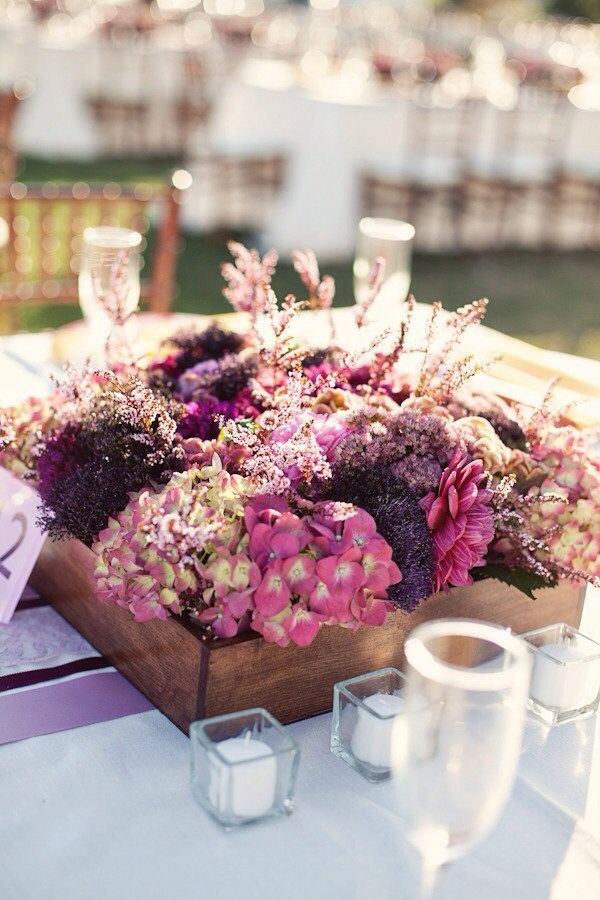 a bright fall wedding centerpiece of pink and purple blooms and herbs is a stylish idea for a barn wedding