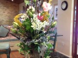 a tree stump with greenery and pink and white blooms plus herbs for plenty of texture