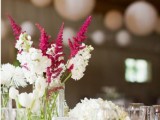 white and fuchsia blooms and greenery in clear vases are simple and cute barn wedding centerpieces