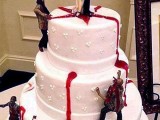 a white bleeding wedding cake with a couple topper with guns and zombies climbing to them is a fun idea for Halloween