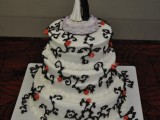 a white patterned wedding cake with dancing skeleton toppers is a stylish idea for Halloween