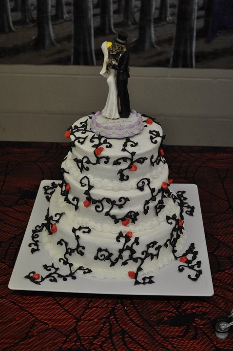 a white patterned wedding cake with dancing skeleton toppers is a stylish idea for Halloween