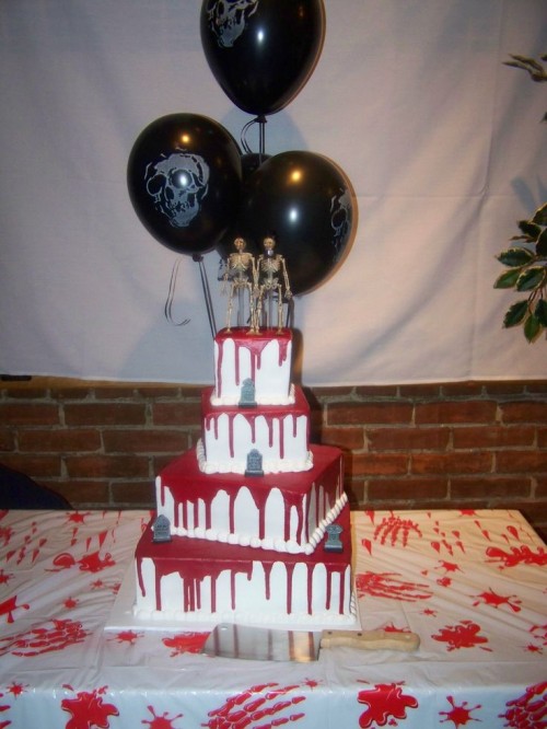 a bloody square wedding cake with grave stones and skeletons on top is a stylish idea for a Halloween wedding