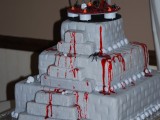 a bloody square buttercream wedding cake with skeletons on top is a nice idea for a Halloween wedding