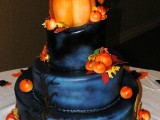 a black navy wedding cake with a scary tree, faux pumpkins, faux leaves and a large pumpkin with quirky toppers for a Halloween wedding