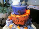 a purple and orange wedding cake with cut tiers, various patterns, letters and monograms, spiderwebs and Mickey Mouse toppers for fun