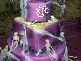 a purple square and round wedding cake with skulls, skeletons, spiderwebs plus skull toppers and colorful touches
