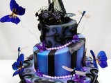 a black, blue and purple Halloween wedding cake with different patterns, butterflies and creative Sally and Jack Skellington toppers
