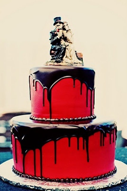 a red chocolate drip wedding cake with skeleton toppers is a nice and chic idea for a Halloween wedding