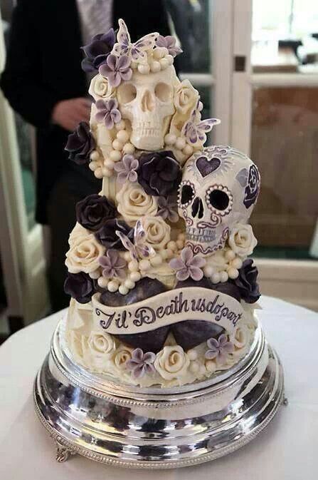 a crazy pastel wedding cake with sugar blooms, skulls and signs, butteflies and beads is a unique idea for Halloween
