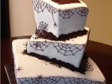 a square spiderweb wedding cake with a grave with gravestones on top and chocolate as ground