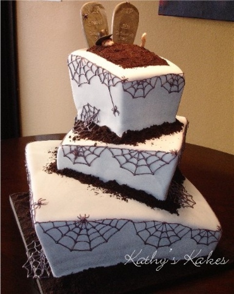 a square spiderweb wedding cake with a grave with gravestones on top and chocolate as ground
