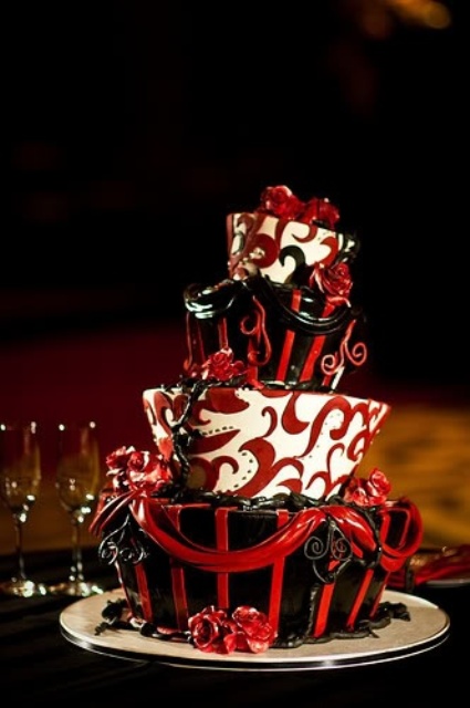 a quirky black, red and white wedding cake with sugar patterns and draperies and sugar red roses for a Halloween wedding
