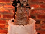 a white buttercream wedding cake with unique skeleton toppers cutting a cake is a very unusual and bold idea