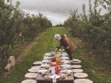a simple rustic picnic with stumps, with a low table, simple porcelain and food right in the vines