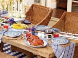 a rustic bright picnic with printed textiles, bright blooms, porcelain and wicker chairs