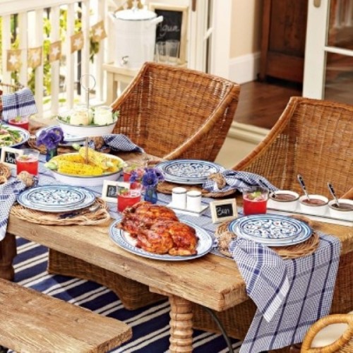 a rustic bright picnic with printed textiles, bright blooms, porcelain and wicker chairs