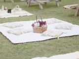 a summer picnic setting with a printed pillows, a basket with blooms is ideal for a rehearsal dinner