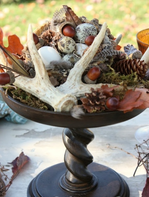 a fall woodland wedding centerpiece of a tall stand with moss, antlers, acorns, pinecones, eggs, leaves and much more