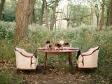 a fall woodland elopement reception space with bold blooms, neutral chairs, candles and elegant gold touches