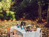 a beautiful and cozy fall woodland wedding reception with bold blooms, greenery, a neutral tablecloth is a chic and cool idea