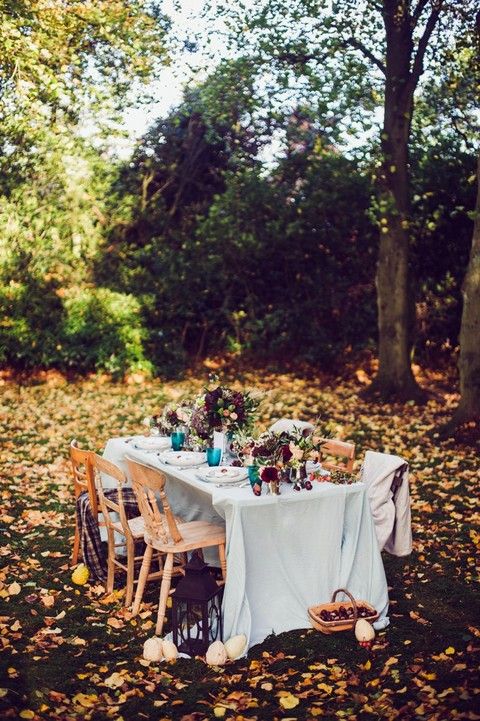 a beautiful and cozy fall woodland wedding reception with bold blooms, greenery, a neutral tablecloth is a chic and cool idea