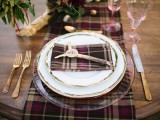 a bold woodland wedding tablescape with plaid linens, gold touches and greenery will be ideal for a fall woodland wedding