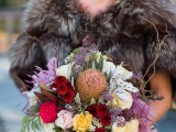 a fall woodland bride in a fur cover up and with a bold wedding bouquet for a fall woodland wedding in jewel tones